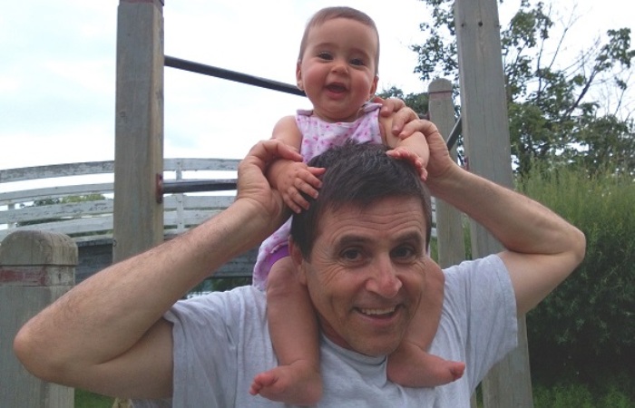 Hassan Diab holding one of his children on his shoulders
