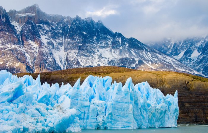 Image of a glacier in front of mountains. Canadian Quakers are taking action around Canada environment and climate change..