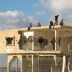 Children play on top of a shell of a building destroyed by Israeli military fire in Gaza