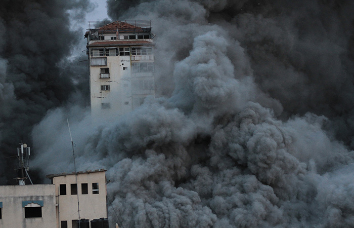 Smoke and flames billow from a high-rise tower in Gaza City, October 7, 2023. Photo by Ali Hamad/ apaimages via Wikimedia Commons CC-BY 3.0