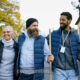 A still shot from the video Alternatives to Prison: Five Effective Methods shows a group of people doing community work smiling and walking together