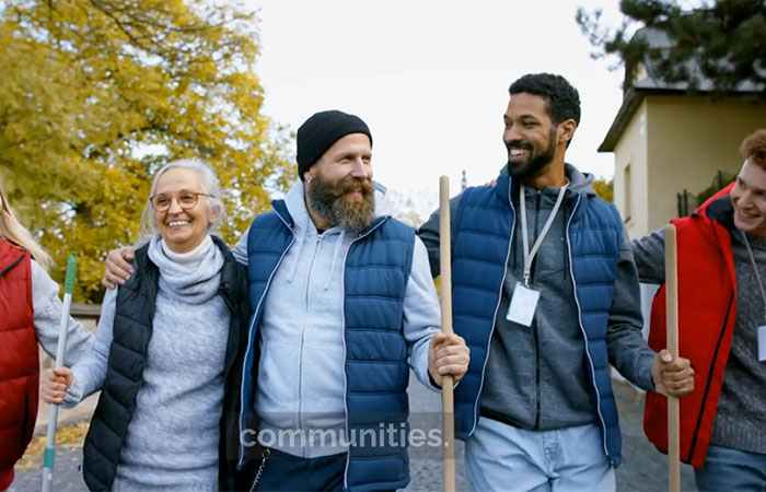A still shot from the video Alternatives to Prison: Five Effective Methods shows a group of people doing community work smiling and walking together