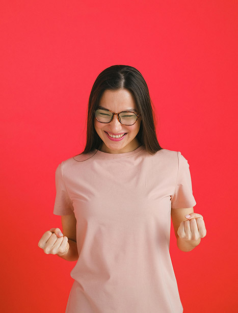 A woman pumps her fists in happiness and excitement.