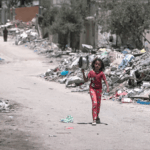 A girl walks to get food in Gaza, 2024. Photo CC-BY Jaber Jehad Badwan/Wikimedia Commons