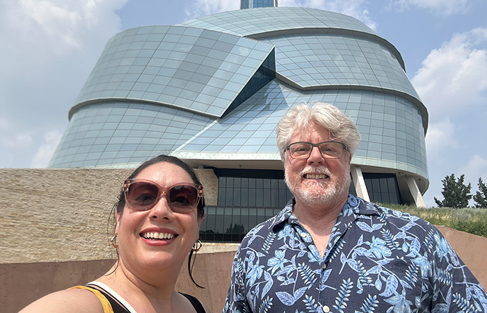 Our staff member Sandra and board member Geoff in front of the Canadian Museum for Human Rights.